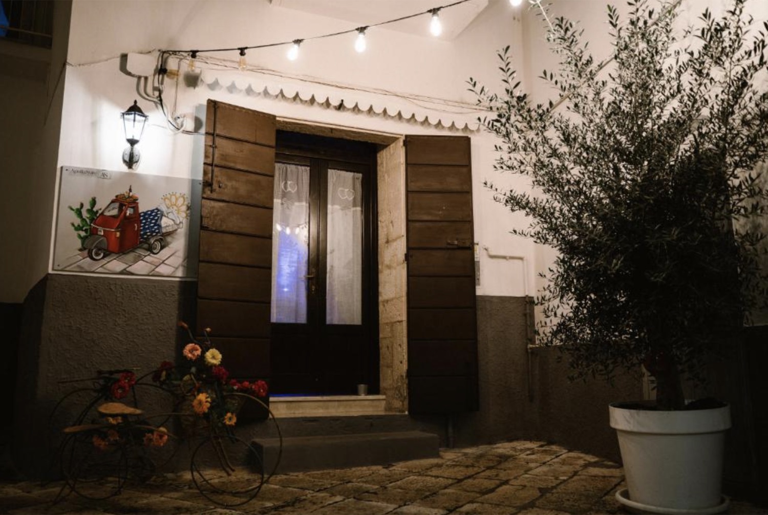 L'ingresso di Apulia Suite a Castellana Grotte, tra ulivo, luci e bicicletta fiorita